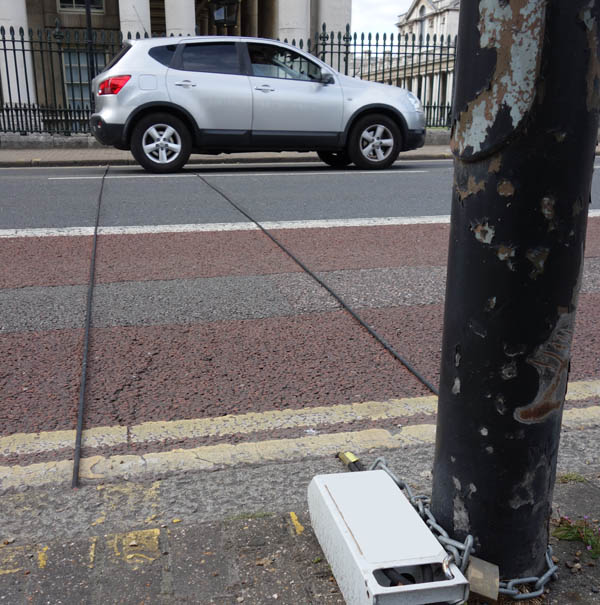 Illustrative picture of a traffic counter (tube counter) on an urban street, with a car crossing it