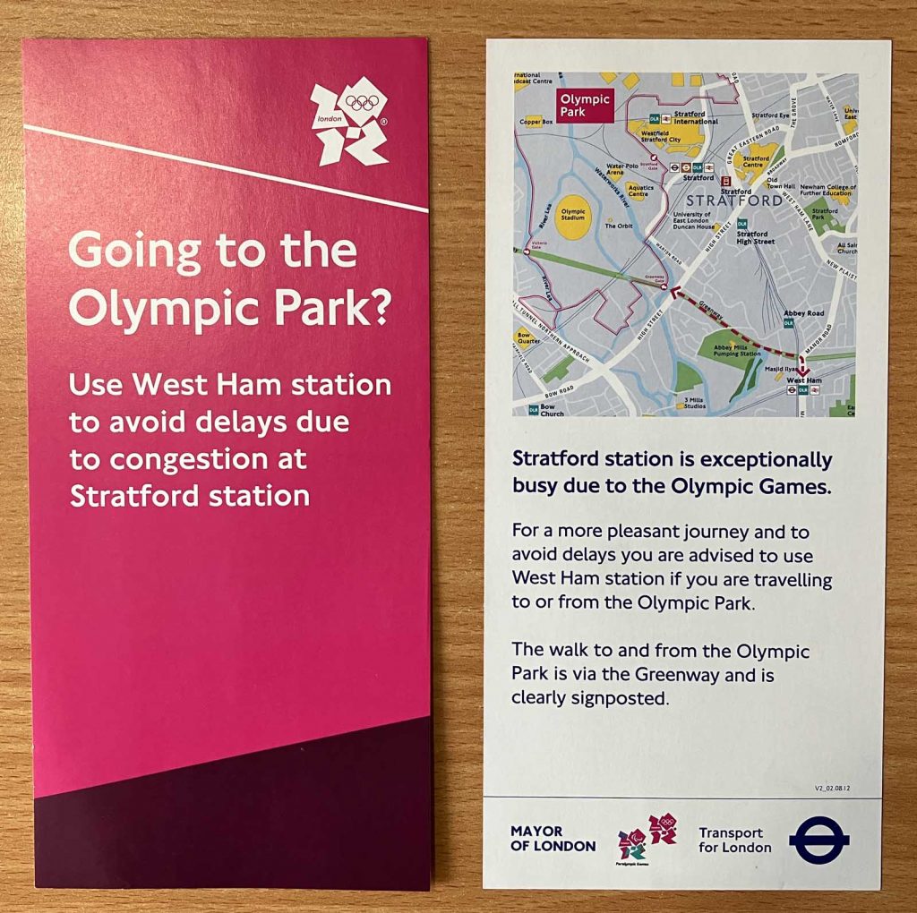 Front and back of a one-third-A4 size leaflet. One side, with a magenta background and the London 2012 logo, has the text "Going to the Olympic Park? Use West Ham station to avoid delays due to congestion at Stratford station". The other side has more detailed text, and a map showing the walking route from West Ham station along the Greenway to the Olympic Park.