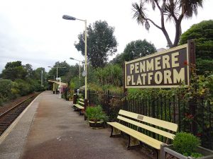 Photo looking along hte platform at Penmere station, a very well-kept and attractive small station with beautiful planting.