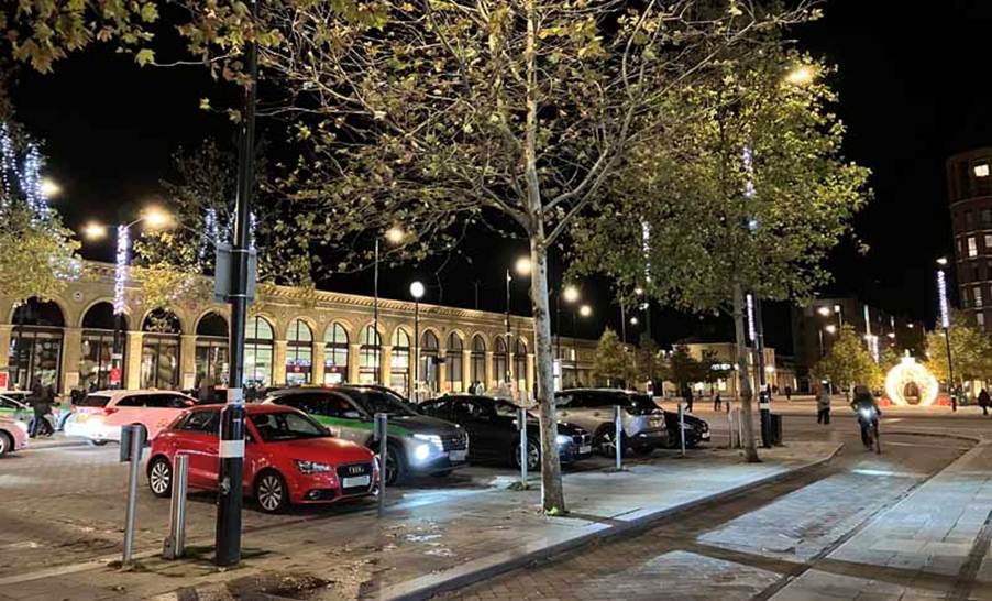 Cambridge station forecourt after dark, with Christmas lights and decorations