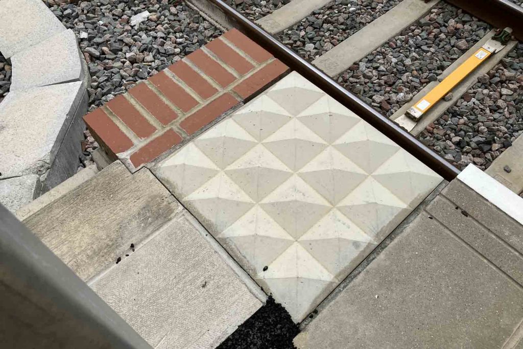 Detail photo of a small set of bricks at a platform end, next to a set of pyramidal "witches' hats".
