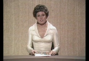 Screenshot of a TV programme with a female newsreader at a desk. The whole thing is very brown in a 1970s way.